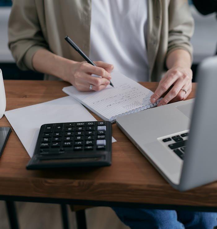 pexels-photo-6962993 Person Calculating on a Notebook